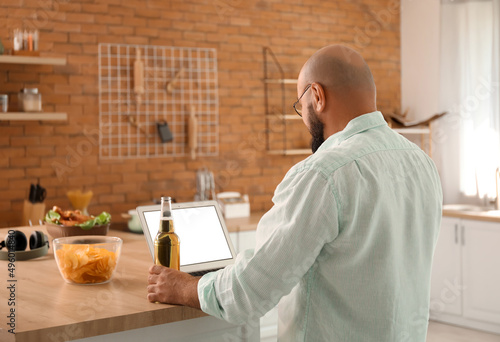 Bald man with laptop drinki...