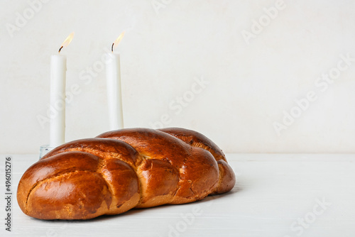 Traditional challah bread with glowing candles on white background. Shabbat Shalom photo