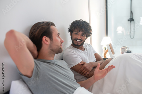 Joyful male looking at his boyfriend during their intimate conversation