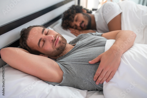 Gay couple lying in bed during the morning sleep