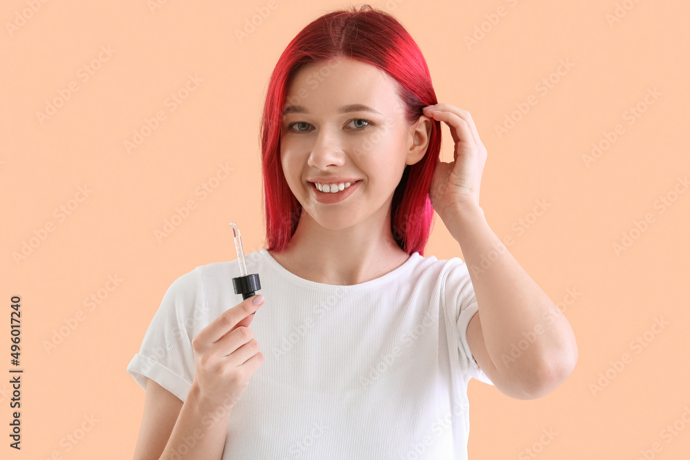Beautiful young woman using serum for hair growth on color background Beautiful young woman using serum for hair growth on color background