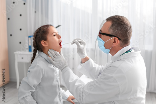 Doctor examining little gir...