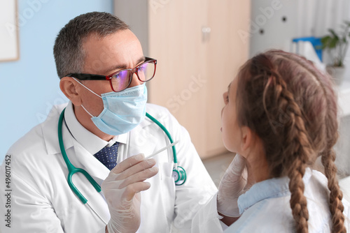 Doctor examining little gir...