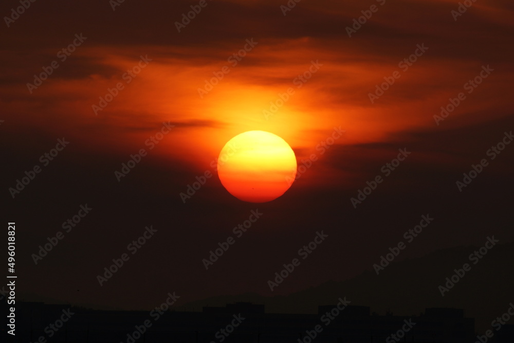 Bright Red Sun rising in red sky
