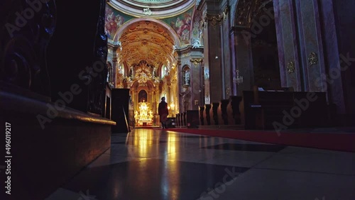 A man walking on the red carpet to the altar Inside Religious Basilica Of Minore Visitation Of The Virgin Mary On Svatý Kopeček In Czech Republic photo