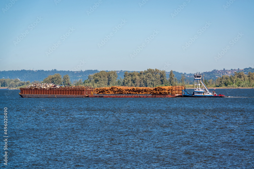 Tugboat carrying scrap metals and logs on the Columbia River, Oregon, USA