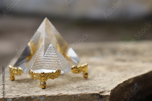 Fototapeta Transparent pyramid, with golden base