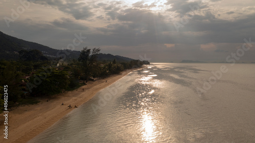 Drone flight photo early evening over ocean and beach - glimmering sunlight in the ocean - Koh Samui island in Thailand