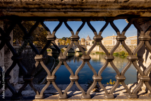 Landscape of Tiber river and saint Peter basilica on the background in Rome. View through the wrought iron fence of the old bridge