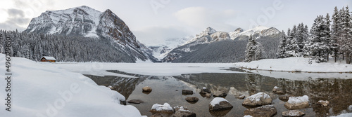 Incredible Lake Louise during winter time with scenic landscape in panorama, panoramic view with snow covering the frozen lake area. 
