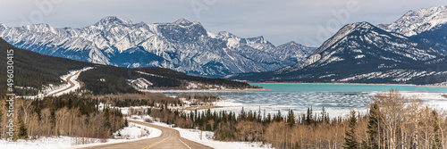 Stunning mountains seen above a frozen lake in Canada during winter time in panoramic view with wallpaper, desktop aesthetic.  © Scalia Media