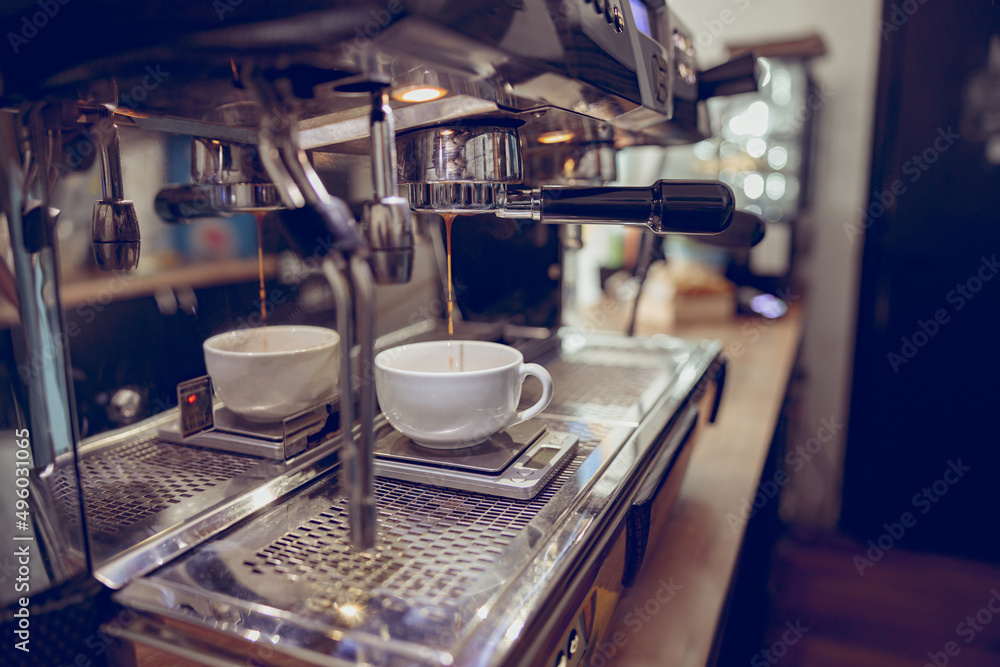 Modern coffee machine brewing espresso in cafeteria