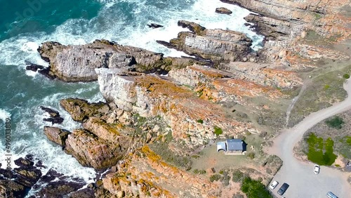 Circling birds eye view of rocky coastline travel destionation and waves crashing into cliff photo