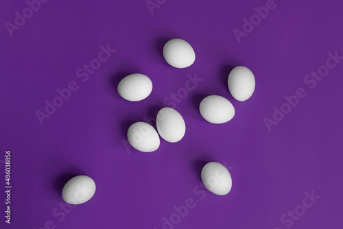white eggs in a grid on a purple background postcard for easter minimalism