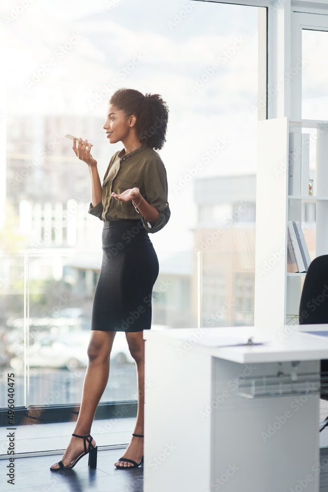 Be bold and stand out above the rest. Full length shot of a young businesswoman standing in her office and busy talking on a smartphone. Be bold and stand out above the rest. Full length shot of a young businesswoman standing in her office and busy talking on a smartphone.