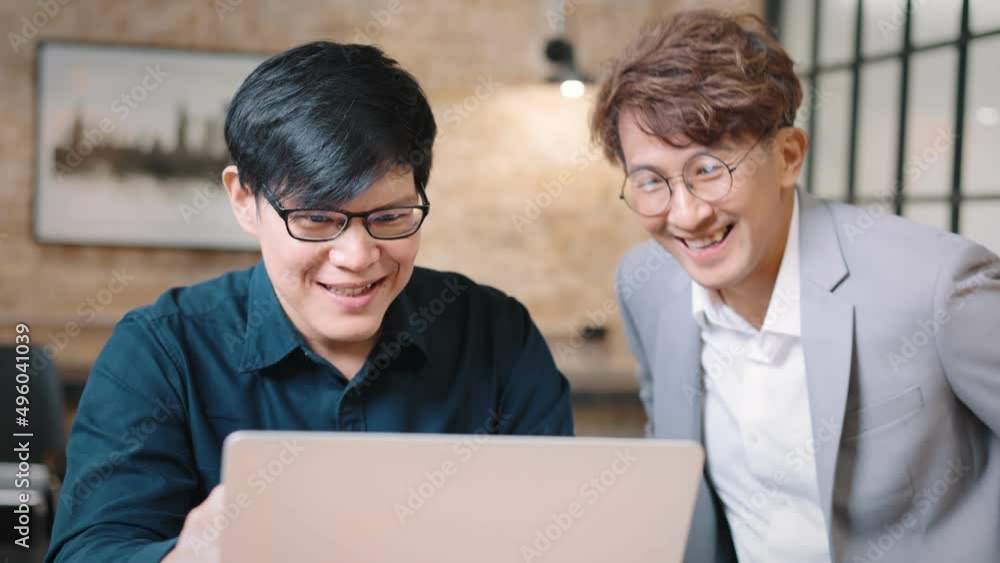 Two asian businessmen chatting while sitting in office. Male sharing ideas or startup business plan with coworker. Business planning. Two asian businessmen chatting while sitting in office. Male sharing ideas or startup business plan with coworker. Business planning.