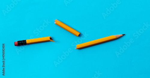 Broken pencil on blue background