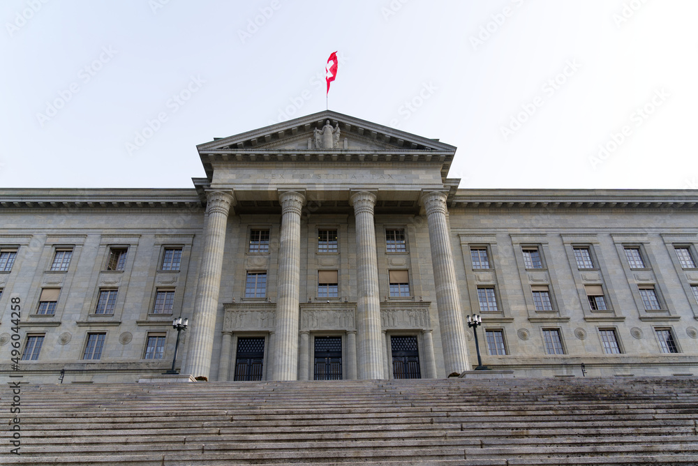Φωτογραφία Federal supreme court of Switzerland with stairway at City of Lausanne on a cloudy spring day with waving Swiss flag