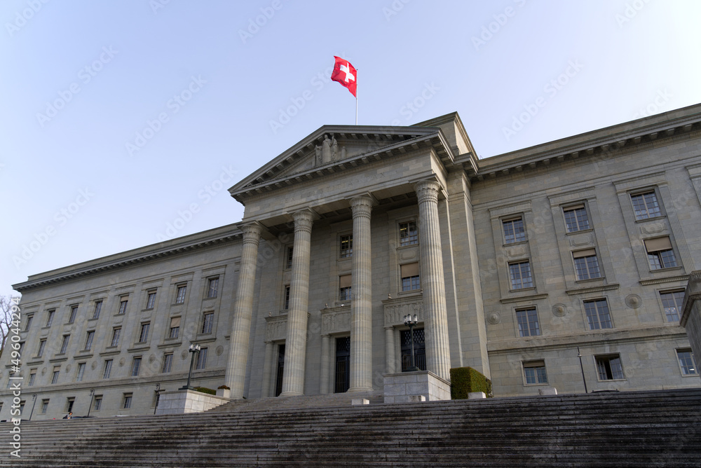 Φωτογραφία Federal supreme court of Switzerland with stairway at City of Lausanne on a cloudy spring day with waving Swiss flag