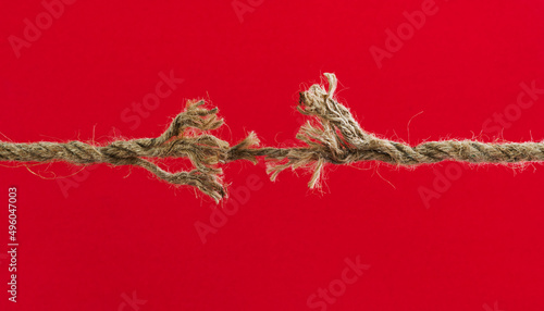 Broken rope on red background