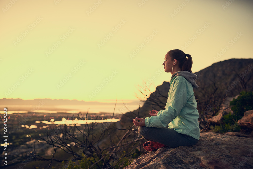Naklejka premium Meditation with a view. Full length shot of a sporty young woman meditating outdoors.