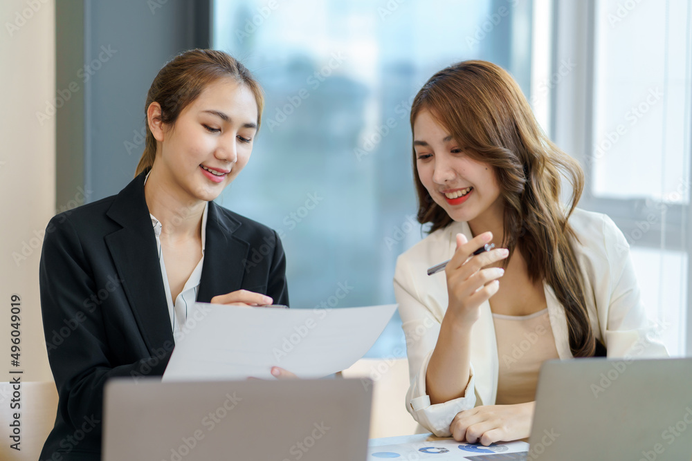 Two beautiful young Asian businesswoman in the conversation, exchanging ideas presentation analyze plan marketing and investment. Two beautiful young Asian businesswoman in the conversation, exchanging ideas presentation analyze plan marketing and investment.