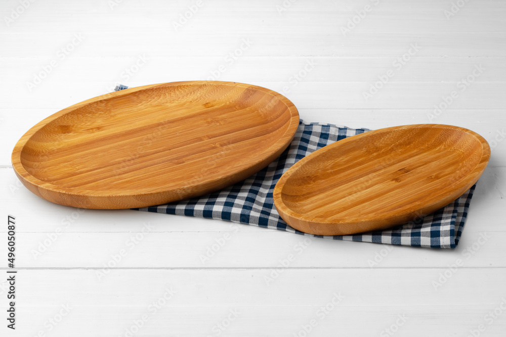 Wooden cutting board on cotton napkin on white wooden table