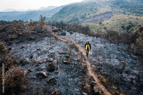 Fényképezés After wildfire, man walking acroos the ash field, Sai Kung, Hong Kong, Asia