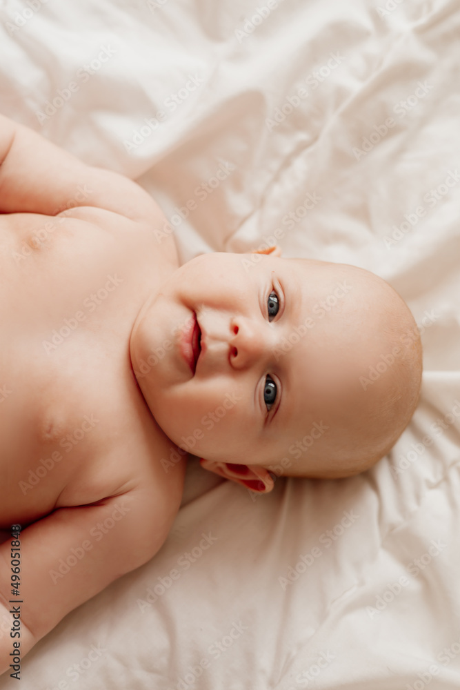 closeup portrait of a blue-eyed newborn baby lying on his back on a white sheet closeup portrait of a blue-eyed newborn baby lying on his back on a white sheet