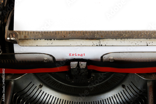 The German word Krieg written in red on an old mechanical typewriter German Text: war