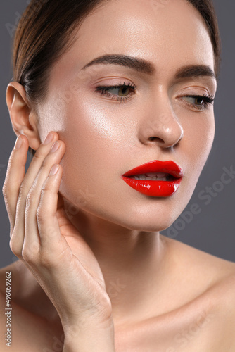 Young woman with red lips makeup on grey background