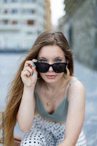 Joven rubia posando en la calle con gafas de sol