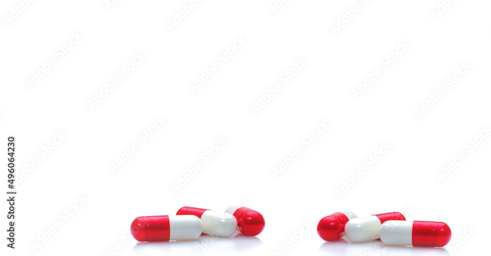 Group of red-white capsule pills on horizontal white background. Prescription drugs. Pharmacy drugstore web banner. Healthcare and medical background. Drug production. Daily dose for love booster. Group of red-white capsule pills on horizontal white background. Prescription drugs. Pharmacy drugstore web banner. Healthcare and medical background. Drug production. Daily dose for love booster.