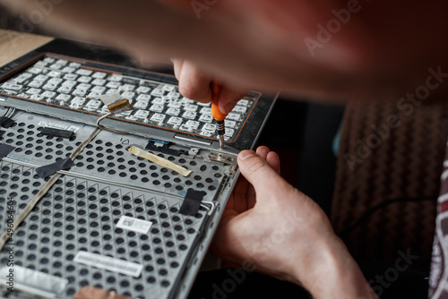 Guy repairs laptop at home
