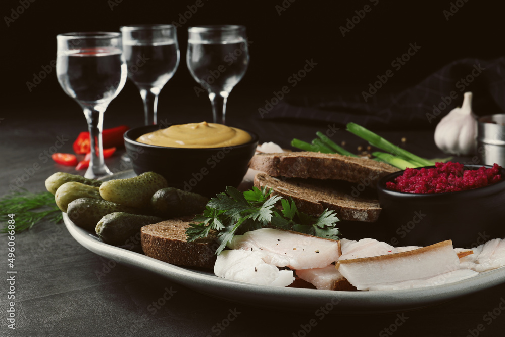 Tasty salt pork with rye bread and sauces served on grey table Tasty salt pork with rye bread and sauces served on grey table