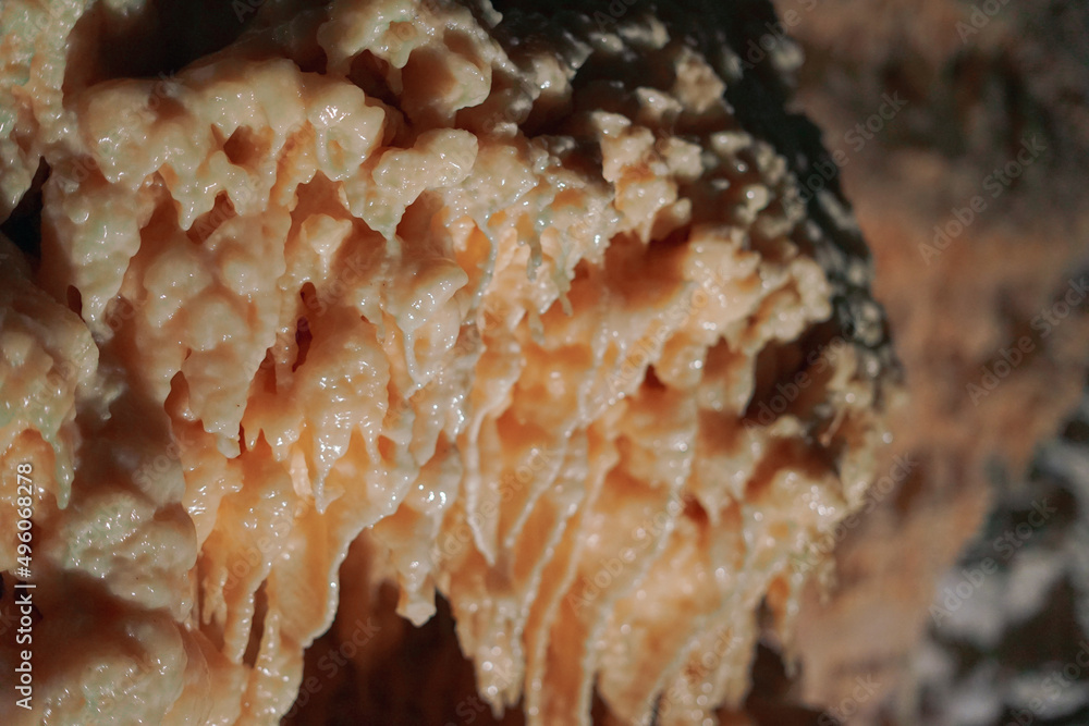 Fototapeta premium Frasassi Caves in Italy. Spectacular caverns in Le Marche. Close-ups of huge limestone columns. Illuminated stalactites and stalagmites under the mountains. Charm, mystery and caving.