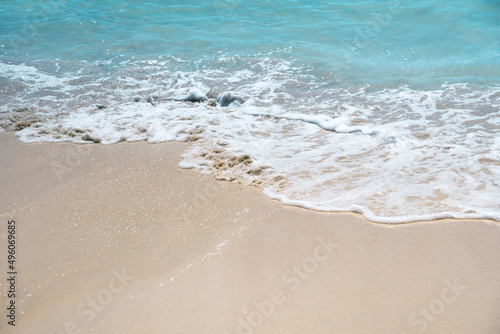 Soft blue oceans wave with foam and clear white sand. Tropical beach by the ocean 