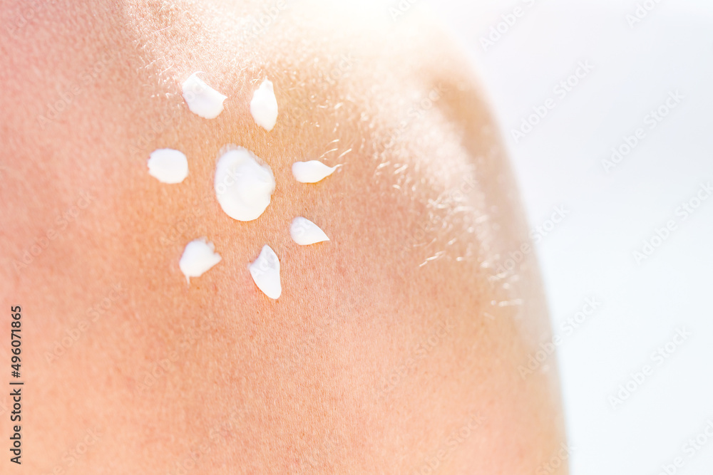 Fototapeta premium Skin and Body Care. Tanned Shoulder and Applying Sun Cream In Form Of The Sun. Sun Protection. Sun Cream.