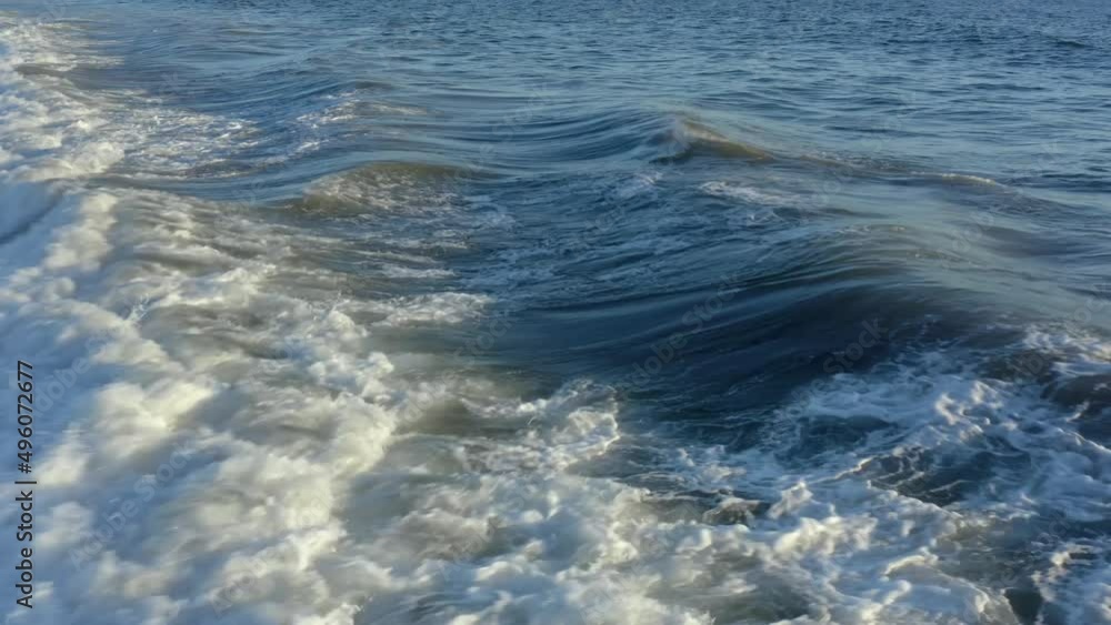 Surfer riding and turning with spray on blue ocean wave Surfer riding and turning with spray on blue ocean wave