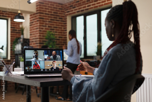African american company team leader in video call digital conference with executive board. Businesswoman discussing through videocall with coworkers about marketing strategy of startup project.
