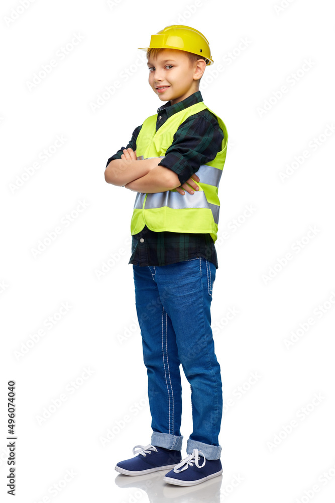 building, construction and profession concept - happy smiling little boy in protective helmet and safety vest with crossed arms over white background