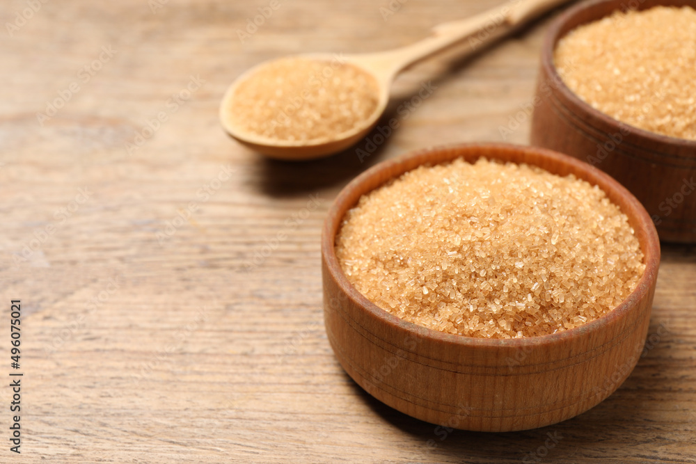 Different dishes with brown sugar on wooden table, closeup. Space for text Different dishes with brown sugar on wooden table, closeup. Space for text