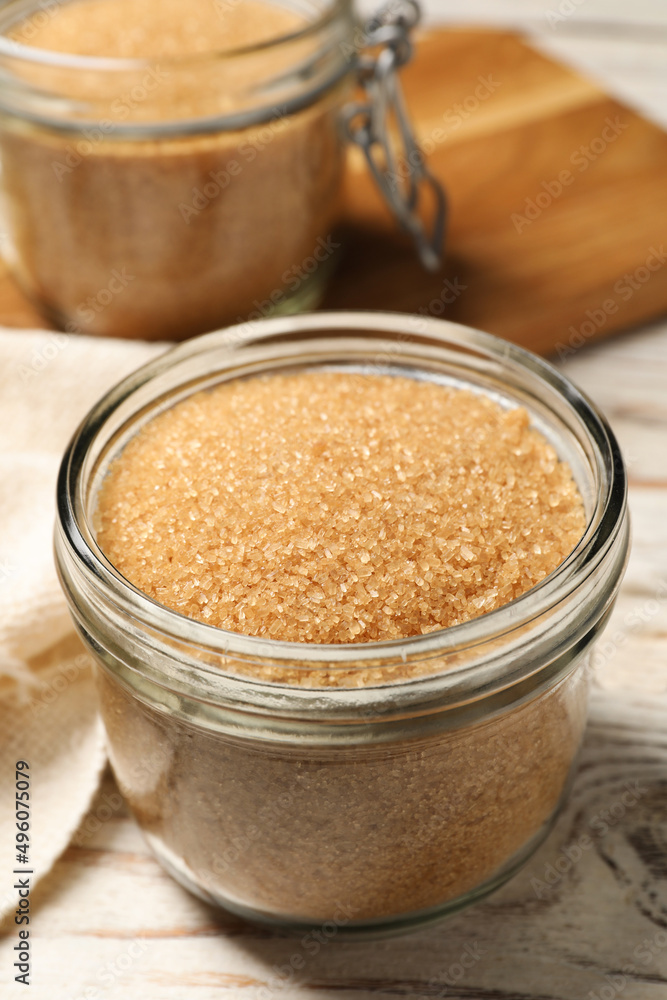 Glass jar with brown sugar on white wooden table, closeup Glass jar with brown sugar on white wooden table, closeup