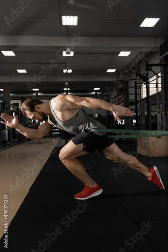 man doing jogging with rubber bands while exercising in the gym