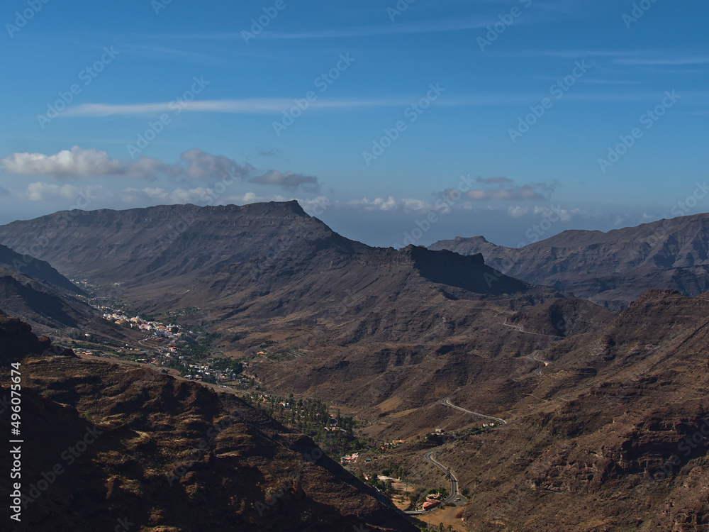 Aerial panoramic view of the south of island Gran Canaria, Spain in the Atlantic Ocean on sunny day with village Mogan surrounded by rugged mountains.