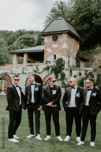 Handsome, stylish groomsmen and groom posing outdoors photo