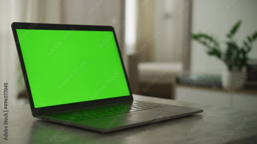 Camera pan over a laptop with a green screen in the apartment Camera pan over a laptop with a green screen in the apartment