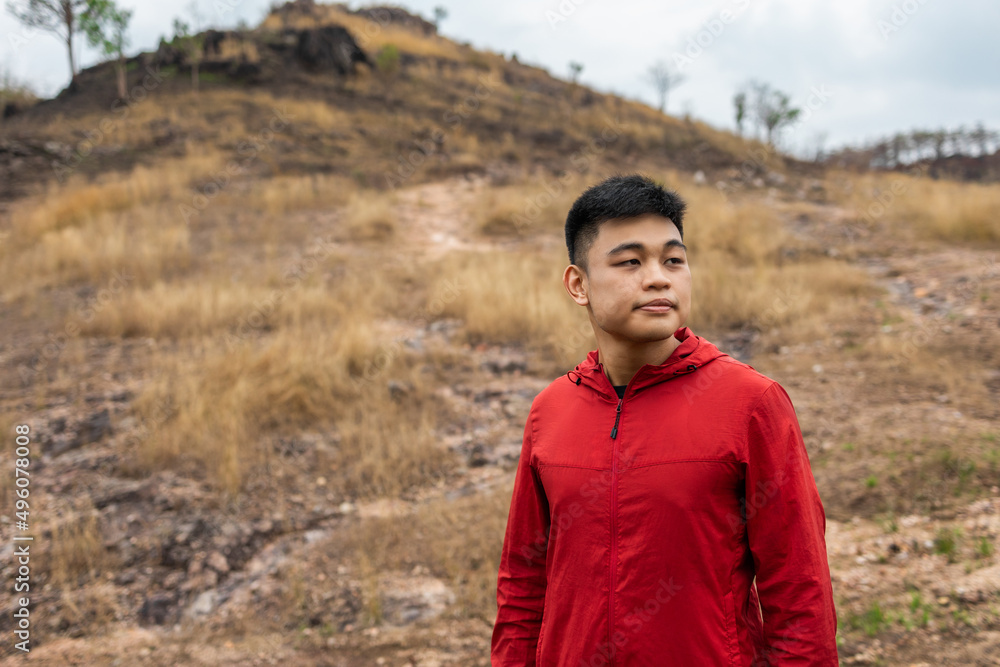 Young handsome asian Trail runner man standing on top of the mountain. Athlete jog outdoor for healthy. Confident and powerful marathon man running workout and cardio. Sport and Lifestyle concept. Young handsome asian Trail runner man standing on top of the mountain. Athlete jog outdoor for healthy. Confident and powerful marathon man running workout and cardio. Sport and Lifestyle concept.