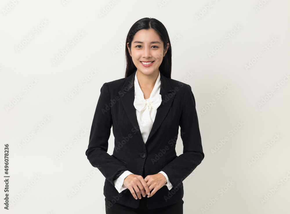 Young asian business woman smiling to camera standing pose on isolated white background. Female around 25 in suit portrait shot in studio. Young asian business woman smiling to camera standing pose on isolated white background. Female around 25 in suit portrait shot in studio.