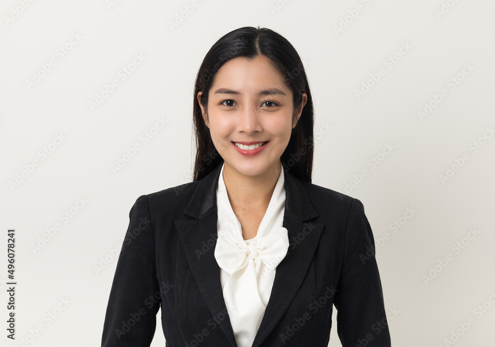 Young asian business woman smiling to camera standing pose on isolated white background. Female around 25 in suit portrait shot in studio. Young asian business woman smiling to camera standing pose on isolated white background. Female around 25 in suit portrait shot in studio.